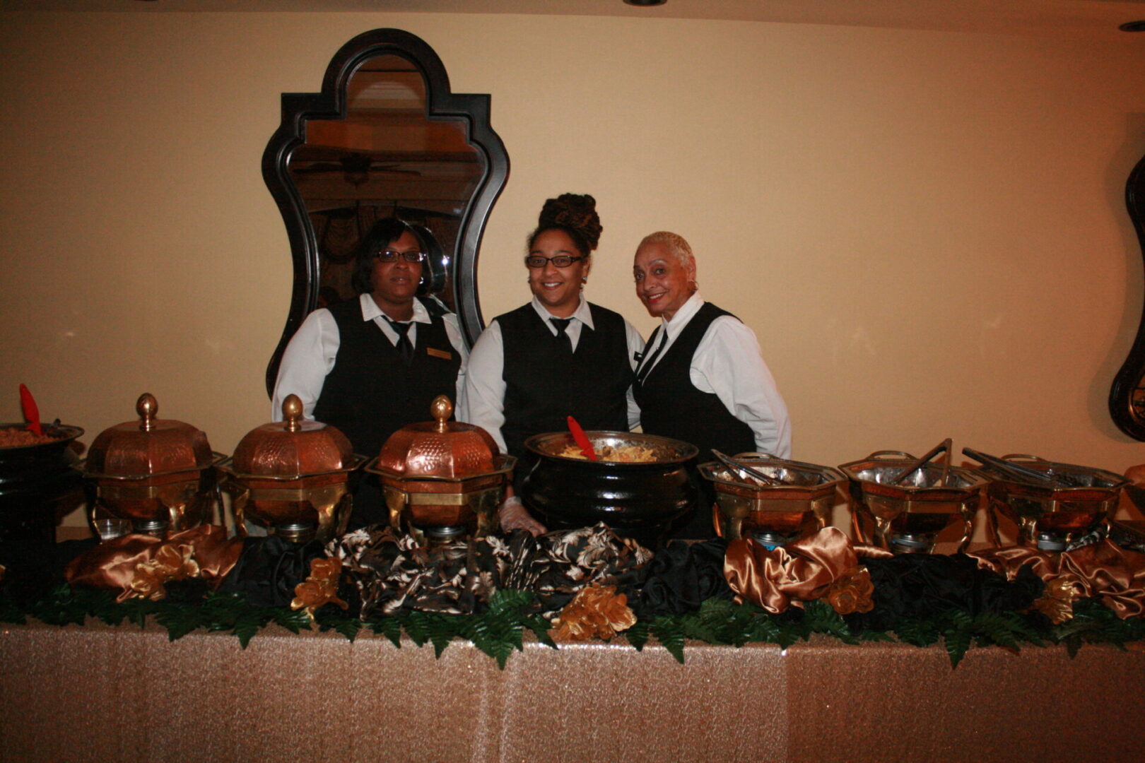 Three people standing in front of a buffet table.
